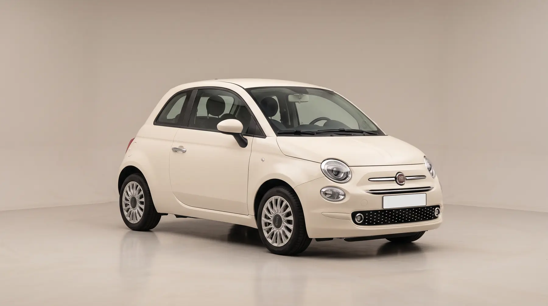 A cream small hatchback in a studio