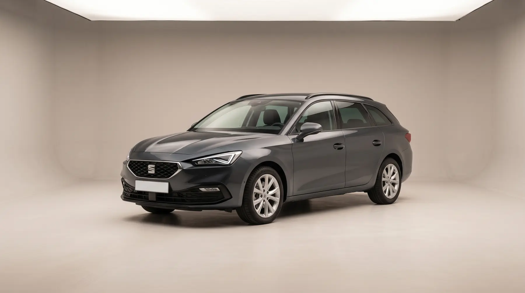 A dark grey estate car in a studio